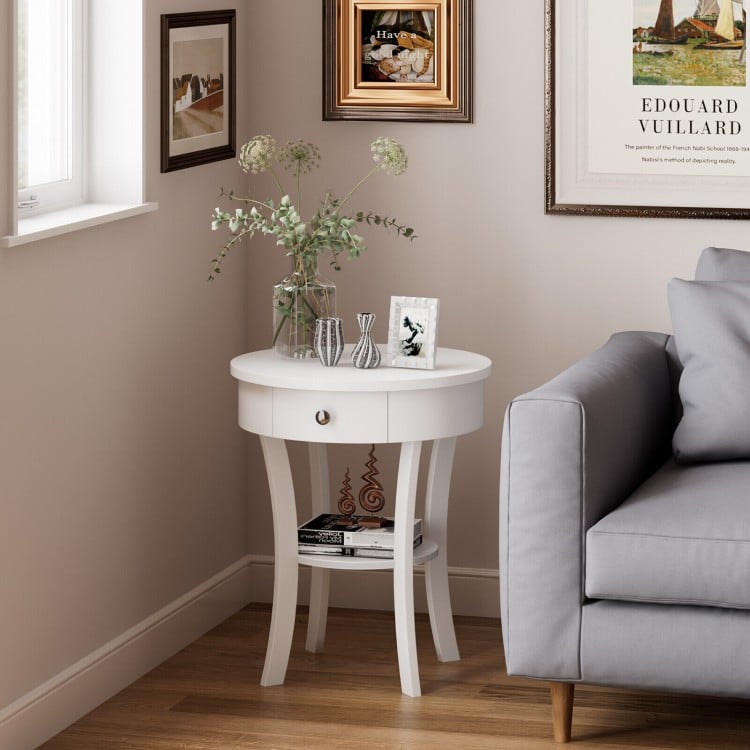 Round white end table with open drawer and shelf, perfect for storage in any living room or bedroom setting.